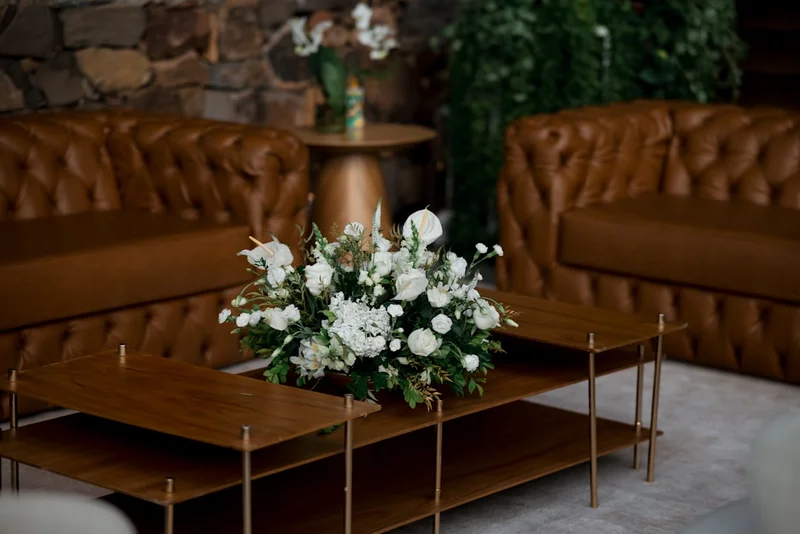 A floral arrangement on a coffee table between sofas